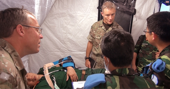 Nhân viên Bệnh viện dã chiến cấp 2 số 1 cùng các chuyên gia quốc tế hội ý nhanh tại khu vực tiếp nhận bệnh nhân.